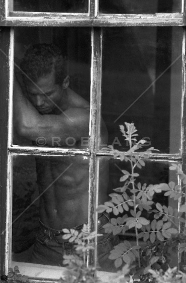 shirtless-man-in-a-window-frame